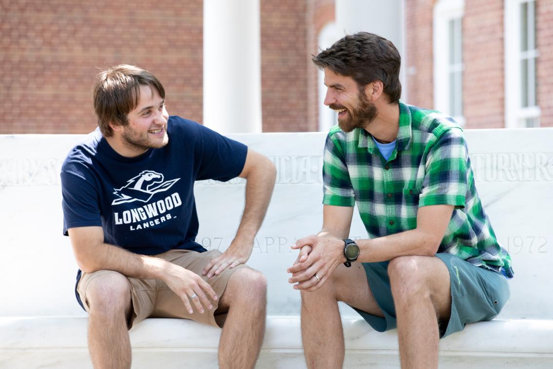 Two people talk on the steps of Chichester